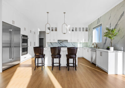 Photograph of an elegant kitchen in a Calgary luxury home featuring marble countertops, state-of-the-art appliances.