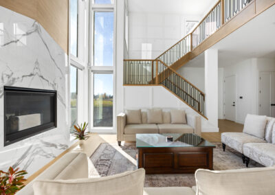 Image of a spacious modern living room in a Calgary luxury home with floor-to-ceiling windows and plush furnishings